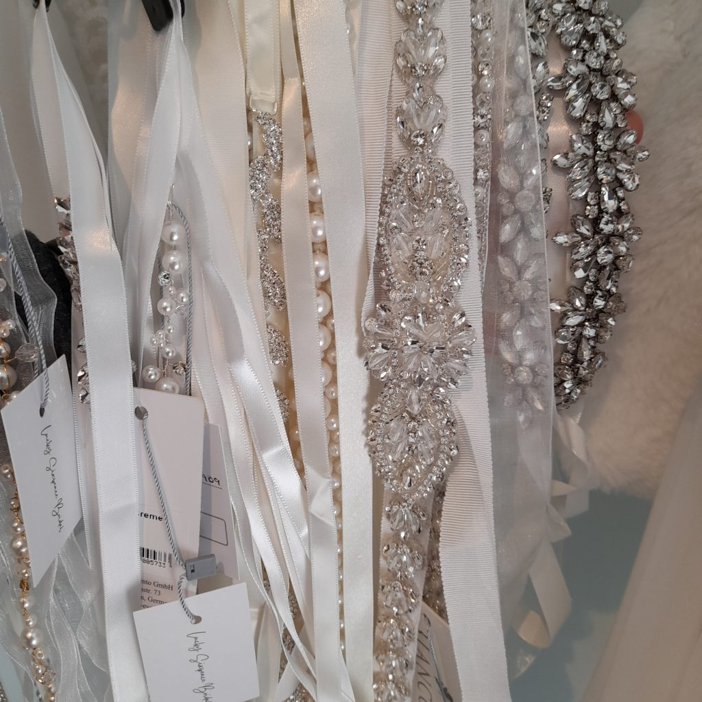 Photo of several bridal belts featuring beads, pearls, crystals, and plain satin ribbon ties.