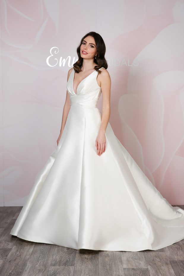 Emma Bridals BL407 is a gorgeous mikado A-line ballgown. This dress features a cross-over bodice and V-neckline, and the back bodice has a lace embellished panel, which is perfect for catching the light as you walk down the aisle.