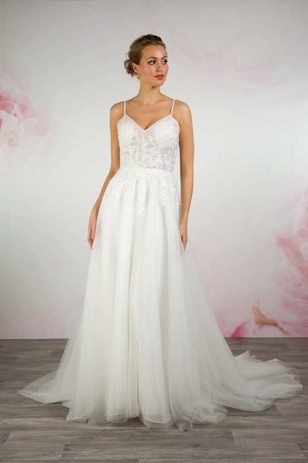 BL354 by Emma Bridals features an ultra-flattering pleated tulle bodice adorned with delicate floral lace with shimmering beads, and a soft tulle skirt. Secured with a zip and buttons at the back.